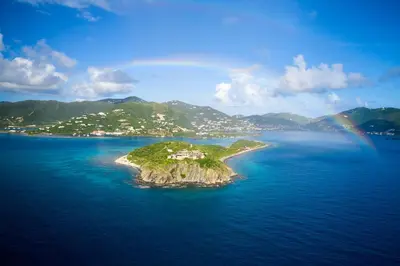 an island in the ocean with a rainbow in the sky at The Aerial, BVI in Tortola Island