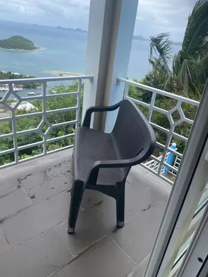 a chair sitting on a balcony looking out at the ocean at Top of the Hill Blue Sunshine in Long Swamp