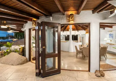 an open door to a patio with a dining table at On The Rocks Villa in Spanish Town