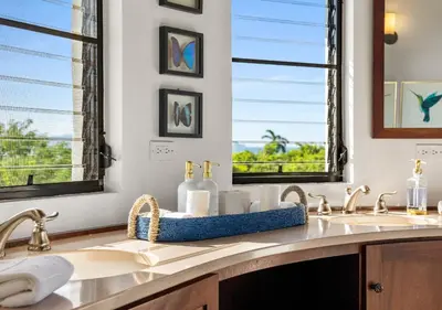 a bathroom with two sinks and two windows at On The Rocks Villa in Spanish Town