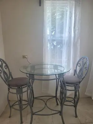 a glass table and two chairs next to a window at Sage Mountain Skyway, Comfortable One Bedroom in Sage Mountain, Tortola in Great Carrot Bay