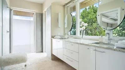 a white bathroom with a sink and a mirror at Oil Nut Bay in Virgin Gorda