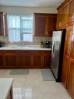a kitchen with wooden cabinets and a stainless steel refrigerator at Ocean Breeze Comfort in East End