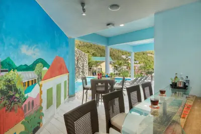 a dining room with a mural on the wall at Cane Garden Bay Beach Hotel in Cane Garden Bay