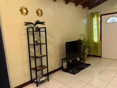 a living room with a television and a shelf at JYM Blissful Escape in Tortola Island