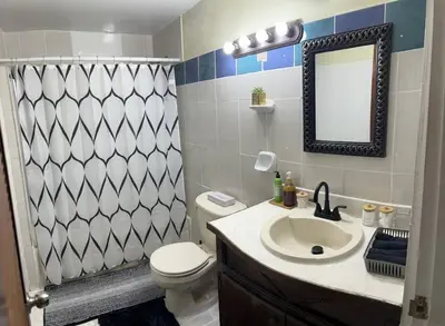 a bathroom with a sink and a toilet and a mirror at JYM Blissful Escape in Tortola Island