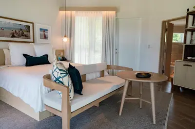 a bedroom with a bed and a table and a couch at Rosewood Little Dix Bay in Virgin Gorda Airport