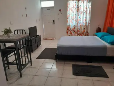a bedroom with a bed and a table and a desk at Abigail Diamond 1 Bedroom near Nanny Cay Marina in Tortola Island