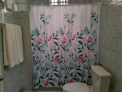 a bathroom with a shower curtain with a flower pattern at Abigail Diamond 1 Bedroom near Nanny Cay Marina in Tortola Island