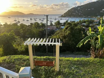a porch swing with a view of a harbor at Cane Garden Bay 2 bed Apt in Leonards