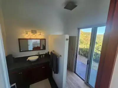 a bathroom with a sink and a mirror at Solace Villa in Little Carrot Bay