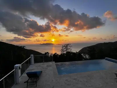 a sunset over the ocean with a swimming pool at Zafira Luxe in Leonards
