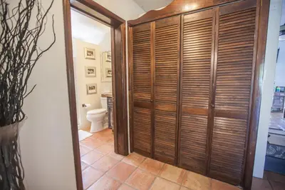 a bathroom with a toilet and a wooden closet at Endless Summer Villa in Tortola Island