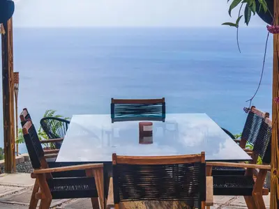 a table and chairs with a view of the ocean at Villa Odyssea BVI in Tortola Island