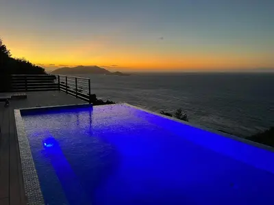 a blue swimming pool with a view of the ocean at Villa Modere' in Tortola Island