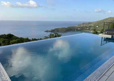 a swimming pool with a view of the ocean at Villa Modere' in Tortola Island