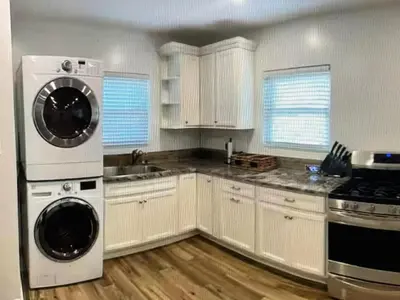a kitchen with white cabinets and a washer and dryer at Amazing place on BVI in Road Town
