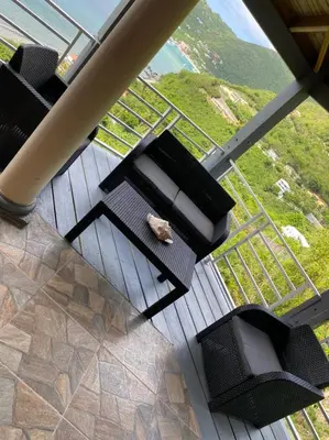 a group of chairs sitting on a wooden deck with a view at Tranquil Escape at Ballast Bay in Road Town