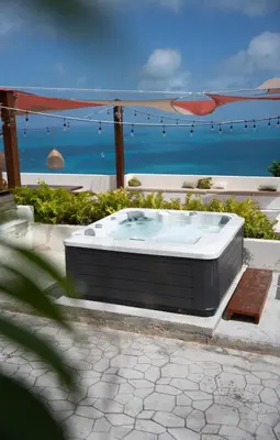 a hot tub with the ocean in the background at Odyssea Oasis in Tortola Island