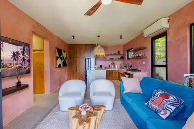 a living room with a blue couch and a kitchen at Odyssea Oasis in Tortola Island
