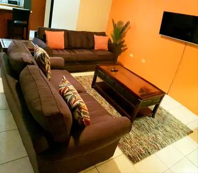 a living room with a couch and a coffee table at SUNFLOWER LANE QUEEN Balcony Room APARTMENT in Tortola Island