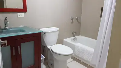 a bathroom with a toilet and a sink and a tub at SUNFLOWER LANE QUEEN Balcony Room APARTMENT in Tortola Island
