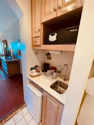 a small kitchen with a sink and a microwave at Sugar Mill Hotel in Great Carrot Bay