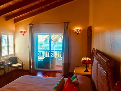 a bedroom with a bed and a window with a view at Sugar Mill Hotel in Great Carrot Bay