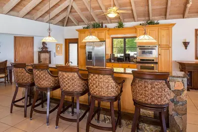 a kitchen with a bar with bar stools at TAMAR VILLA in Virgin Gorda