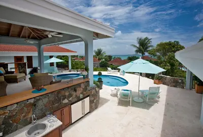 a backyard with a swimming pool and a house at BLUE LAGOON in Virgin Gorda