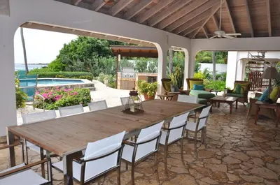 a dining room with a table and chairs and a pool at CARIBBEAN WIND in Virgin Gorda