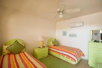a bedroom with two beds and a dresser with a lamp at LOBLOLLY in Virgin Gorda