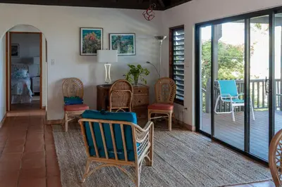 a living room with chairs and a porch with sliding glass doors at VILLA DEL SOLE in Virgin Gorda
