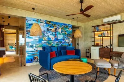 a living room with a blue couch and a table at Saba Rock Resort in Virgin Gorda