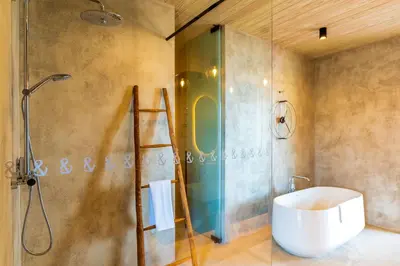 a bathroom with a shower with a sink and a glass shower door at Saba Rock Resort in Virgin Gorda